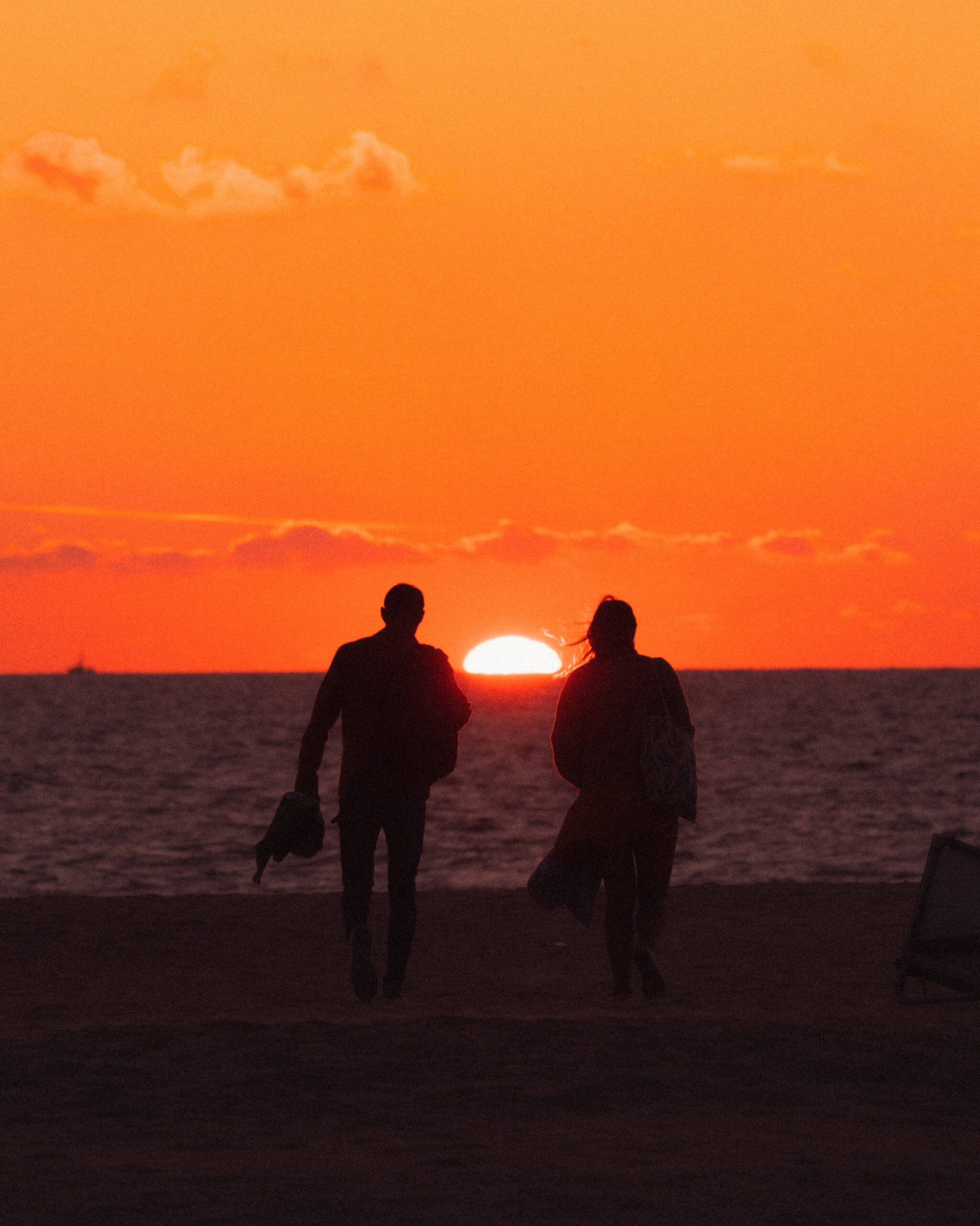 Couple heading towards the Sunset on the beach